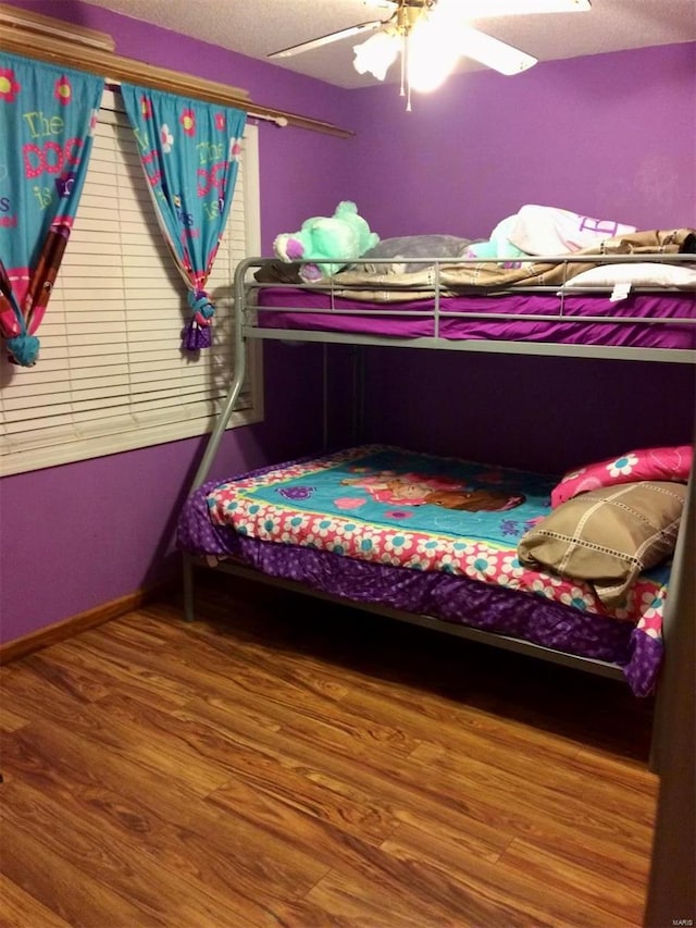 bedroom featuring hardwood / wood-style floors, ceiling fan, and a textured ceiling