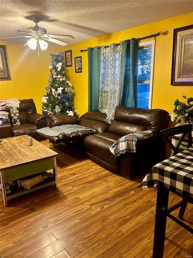 living room with ceiling fan, hardwood / wood-style floors, and a textured ceiling