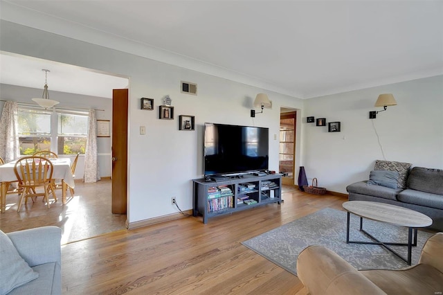 living room featuring hardwood / wood-style flooring and ornamental molding