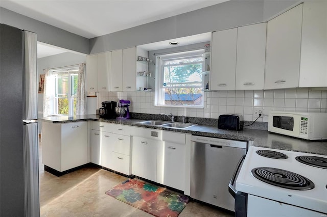 kitchen featuring white cabinets, appliances with stainless steel finishes, a healthy amount of sunlight, and sink