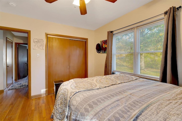 bedroom with a closet, light hardwood / wood-style flooring, and ceiling fan