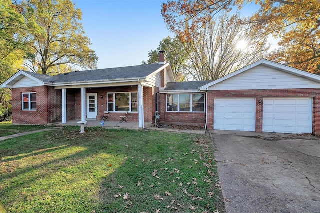 ranch-style home featuring covered porch, a garage, and a front yard