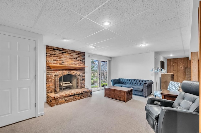 living room with a paneled ceiling and a fireplace