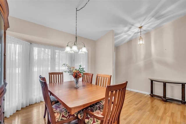 dining area featuring light hardwood / wood-style floors and an inviting chandelier