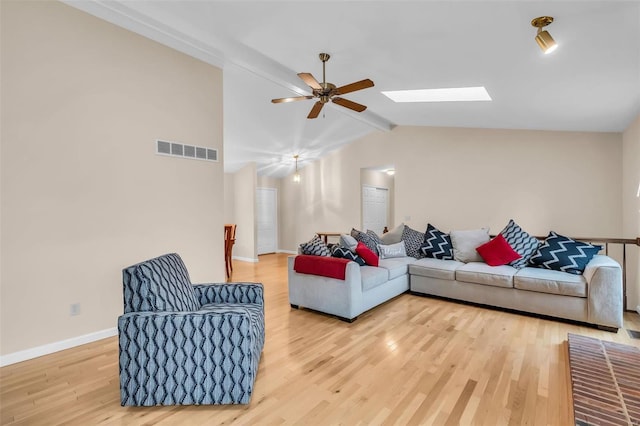 living room with hardwood / wood-style floors, lofted ceiling with skylight, and ceiling fan