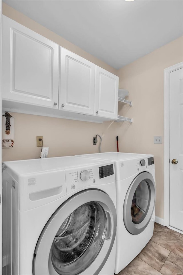 laundry room with cabinets, light tile patterned floors, and separate washer and dryer