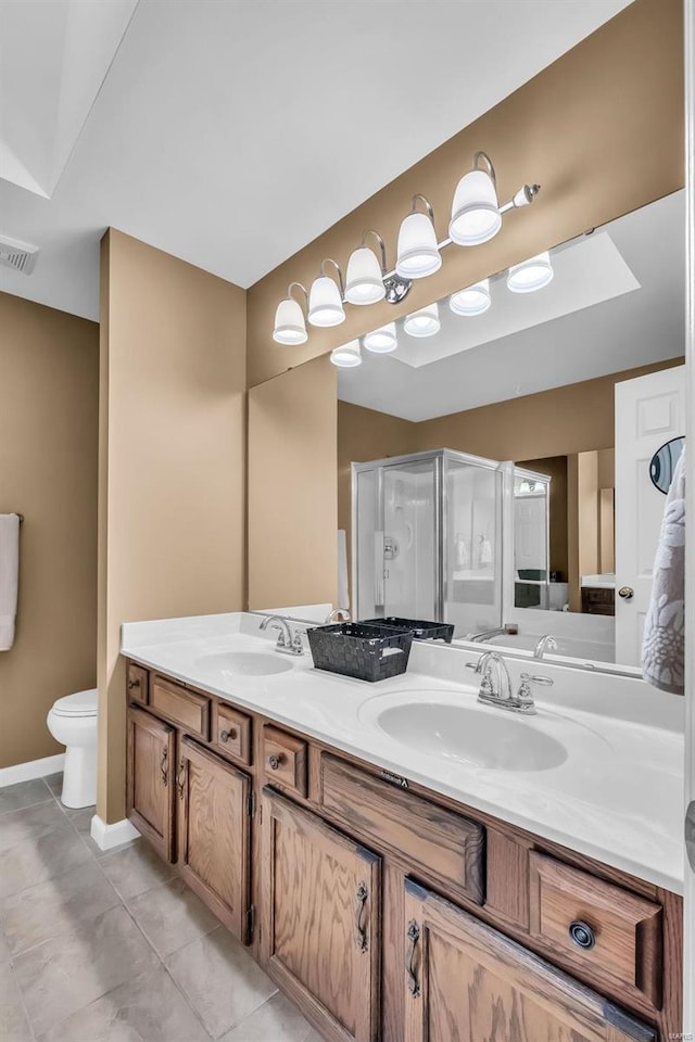 bathroom with tile patterned floors, vanity, an enclosed shower, and toilet