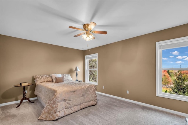 carpeted bedroom featuring ceiling fan and multiple windows