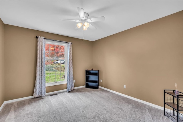 carpeted spare room featuring ceiling fan