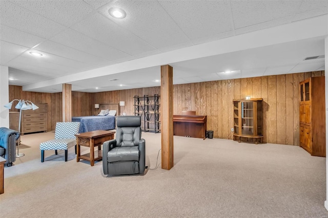 carpeted living room featuring wooden walls