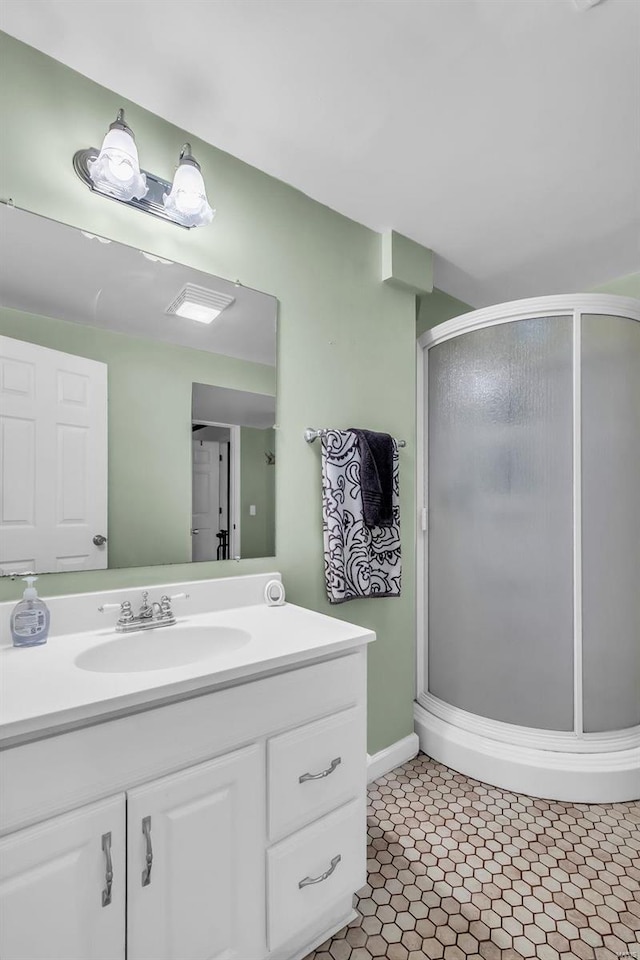 bathroom with tile patterned floors, a shower with door, and vanity