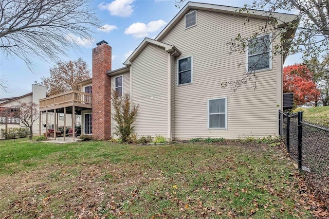 rear view of property featuring a patio area, a yard, and a deck