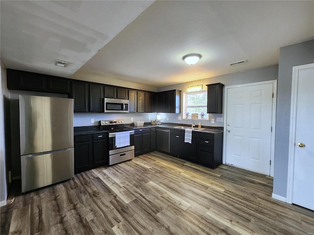 kitchen featuring light hardwood / wood-style flooring, stainless steel appliances, a textured ceiling, and sink