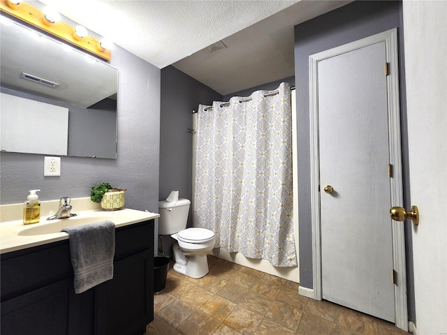 bathroom featuring a shower with curtain, vanity, toilet, and a textured ceiling