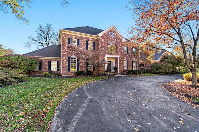 colonial-style house featuring a front yard