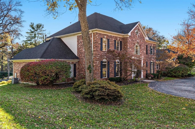 view of side of home featuring a lawn and central air condition unit