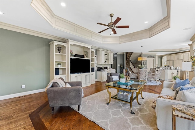 living room featuring light hardwood / wood-style flooring, ceiling fan, and crown molding