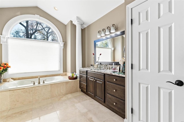 bathroom with decorative columns, tiled bath, tile patterned floors, lofted ceiling, and vanity