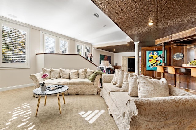 carpeted living room featuring decorative columns, indoor bar, and ornamental molding