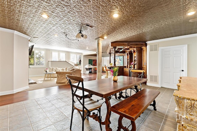 dining room with decorative columns, crown molding, and hardwood / wood-style flooring