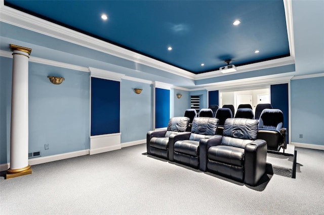 carpeted cinema room featuring ornate columns, ornamental molding, and a tray ceiling