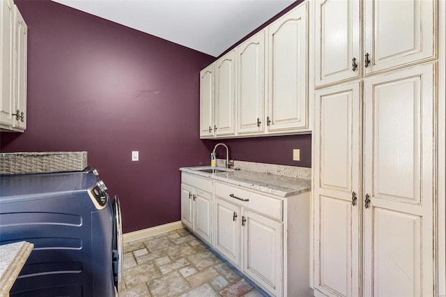 laundry area featuring washer and clothes dryer, sink, and cabinets