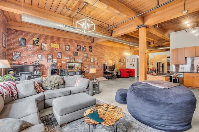 living room with wooden ceiling, an inviting chandelier, sink, beam ceiling, and brick wall