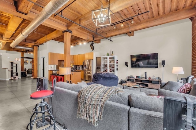 living room with beam ceiling, wood ceiling, concrete flooring, and an inviting chandelier