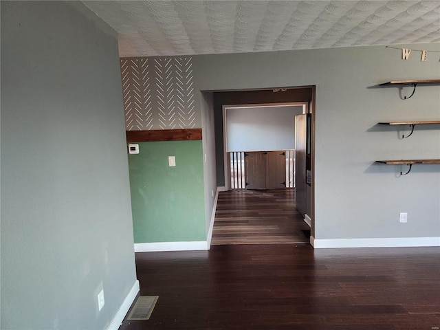 corridor with dark hardwood / wood-style flooring