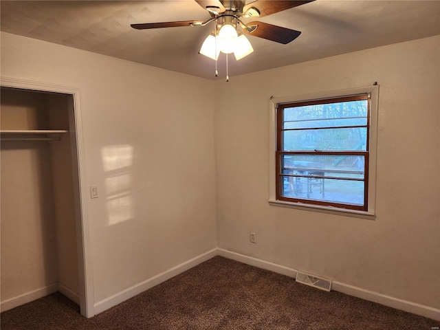 unfurnished bedroom featuring ceiling fan, a closet, and dark carpet