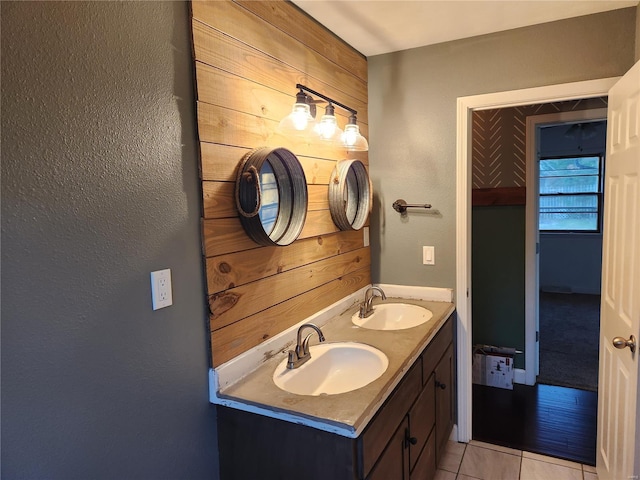 bathroom with tile patterned flooring, vanity, and wooden walls