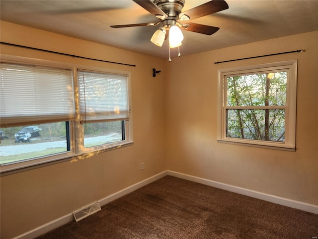 empty room featuring dark colored carpet and ceiling fan