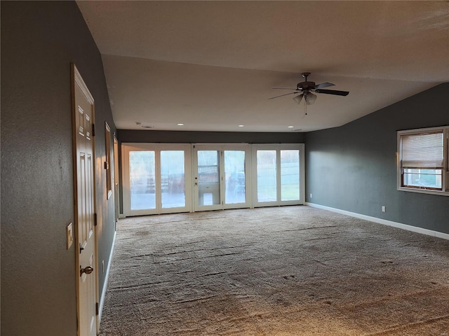 spare room with ceiling fan, carpet floors, a wealth of natural light, and vaulted ceiling