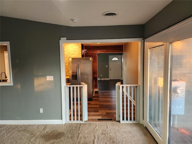 corridor featuring hardwood / wood-style flooring and vaulted ceiling