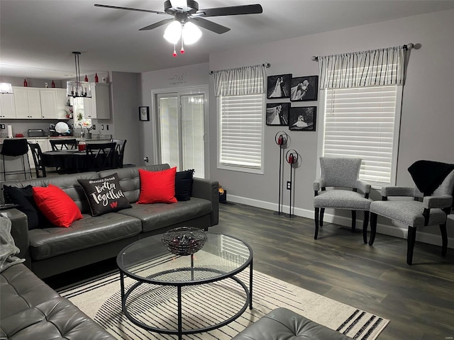 living room featuring ceiling fan with notable chandelier, dark hardwood / wood-style flooring, and a wealth of natural light