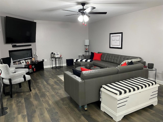 living room featuring ceiling fan and dark wood-type flooring