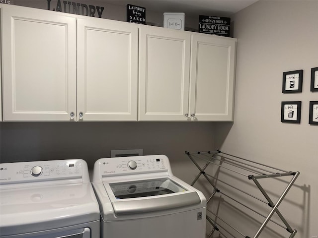 washroom featuring cabinets and independent washer and dryer