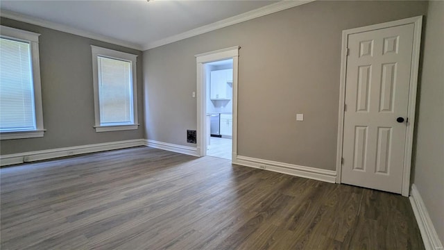 unfurnished room with plenty of natural light, dark hardwood / wood-style floors, and ornamental molding