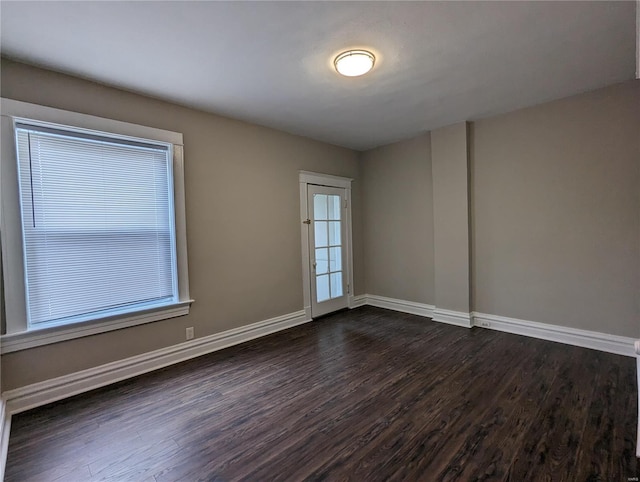 empty room with dark hardwood / wood-style flooring