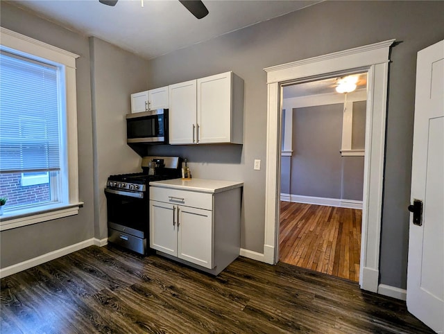 kitchen featuring white cabinets, ceiling fan, dark hardwood / wood-style flooring, and gas range oven