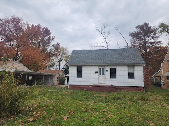 rear view of property with a sunroom and a yard