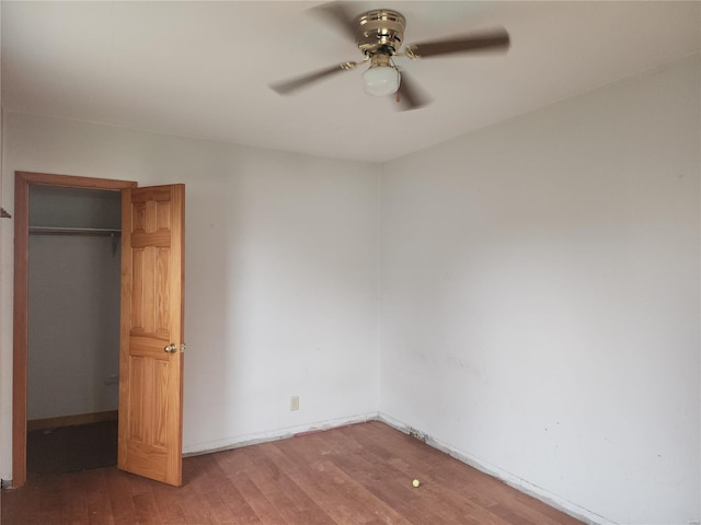 unfurnished bedroom with ceiling fan, a closet, and hardwood / wood-style flooring