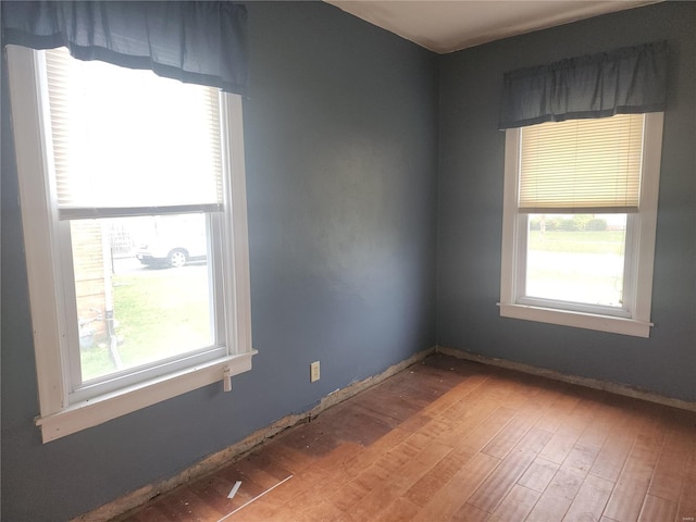 empty room with a healthy amount of sunlight and wood-type flooring