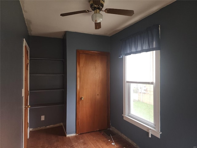 unfurnished bedroom with wood-type flooring, multiple windows, and ceiling fan