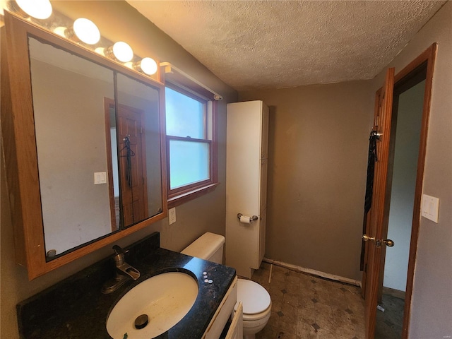 bathroom with vanity, a textured ceiling, and toilet