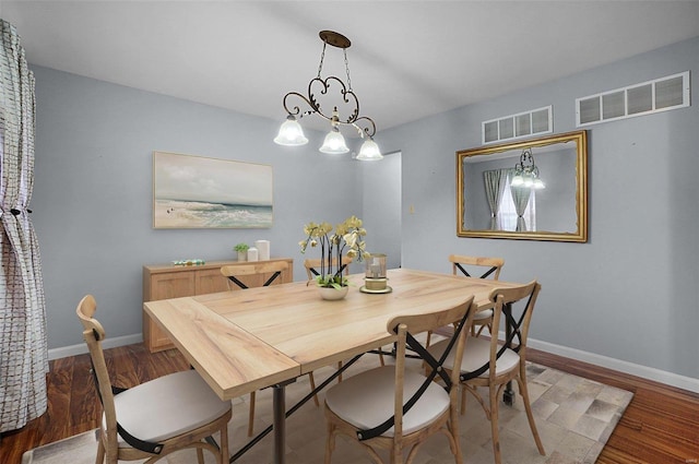 dining room with a notable chandelier and wood-type flooring