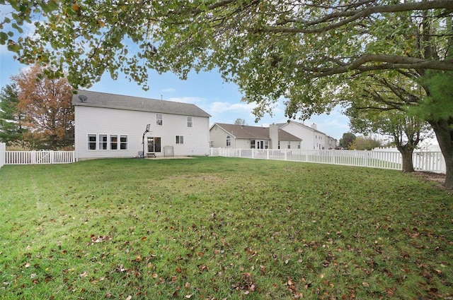 rear view of house featuring a yard