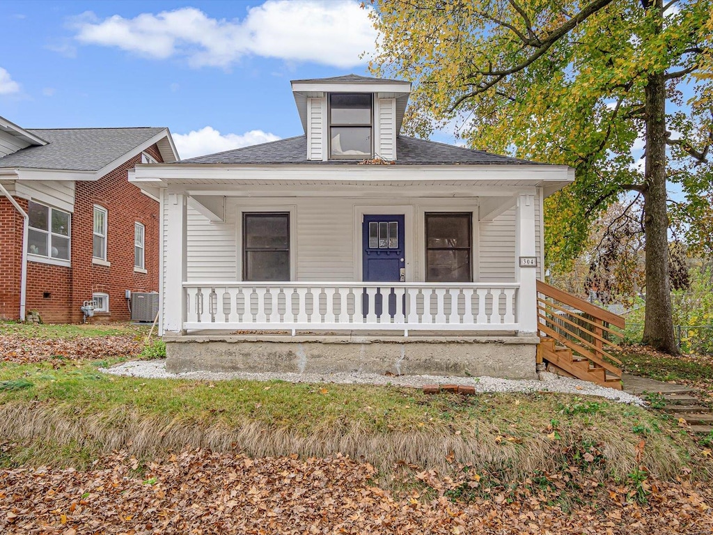 bungalow-style home with a porch and central air condition unit