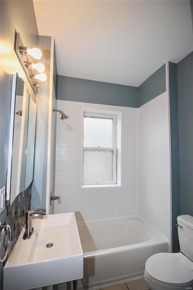 full bathroom with tile patterned floors, sink, tiled shower / bath, and toilet