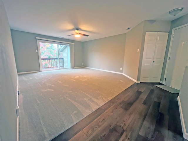 spare room with dark colored carpet and ceiling fan